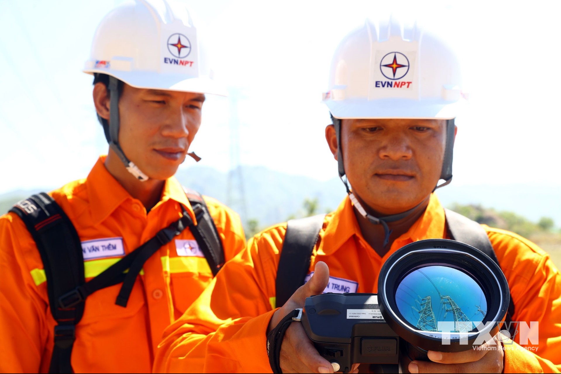 Công nhân đội truyền tải điện Bắc Bình (TTĐ Bình Thuận) dùng ống nhòm soi phát nhiệt kiểm tra đường dây 500kV Vĩnh Tân - Sông Mây. (Ảnh: Huy Hùng/TTXVN)